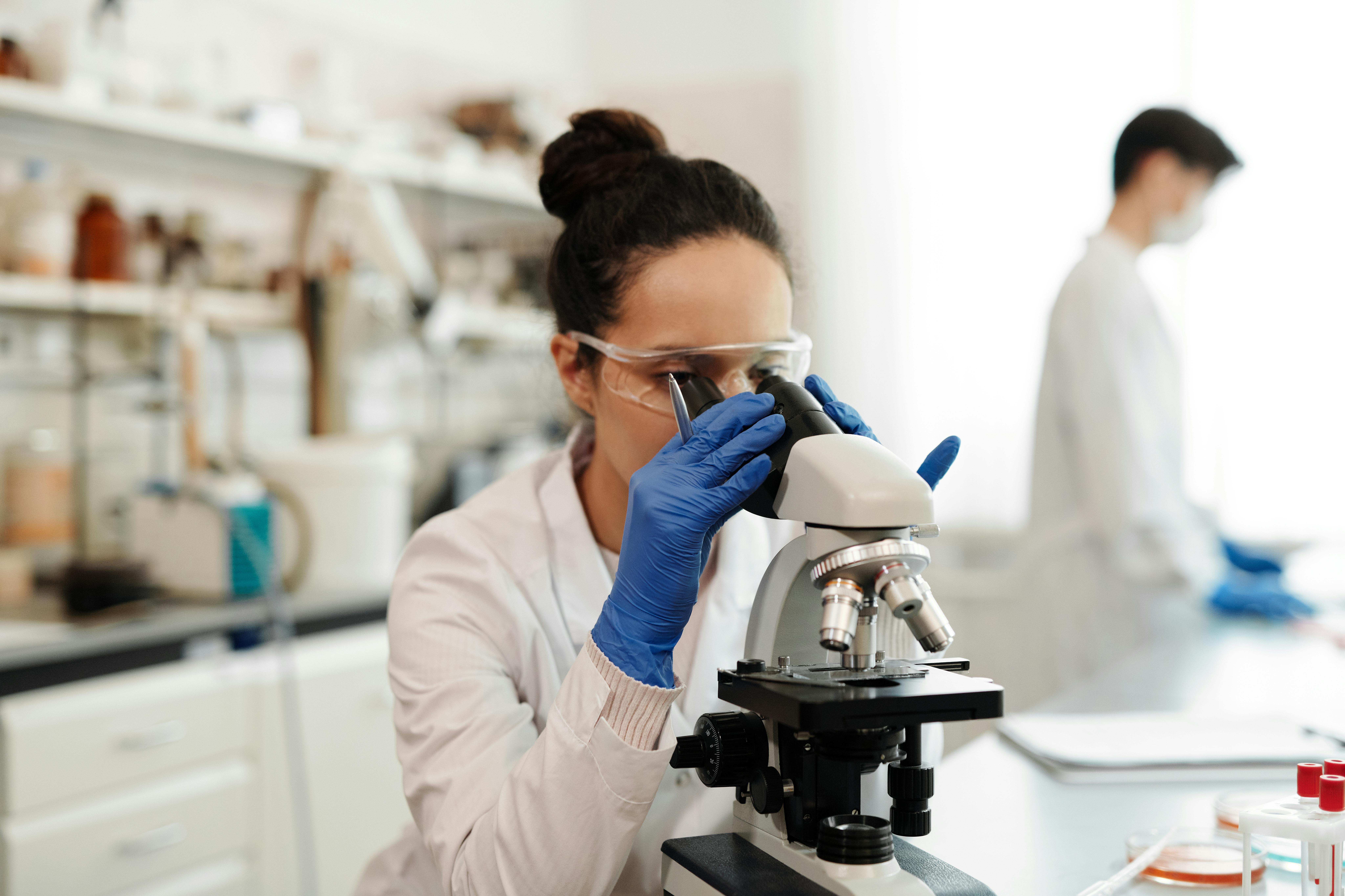 Laboratory technician examining a sample under a microscope
