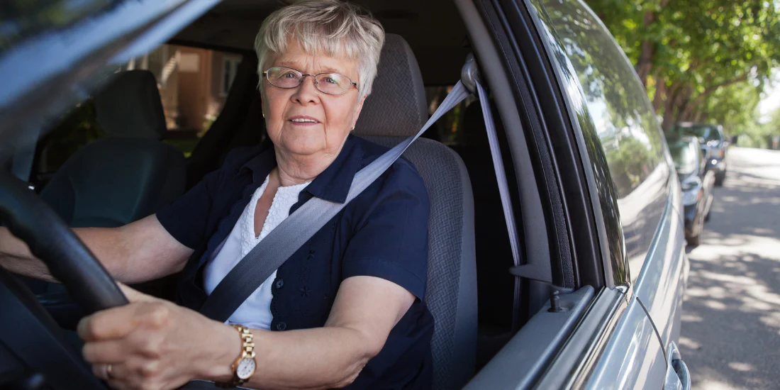 Older woman wearing a seat belt while driving a car